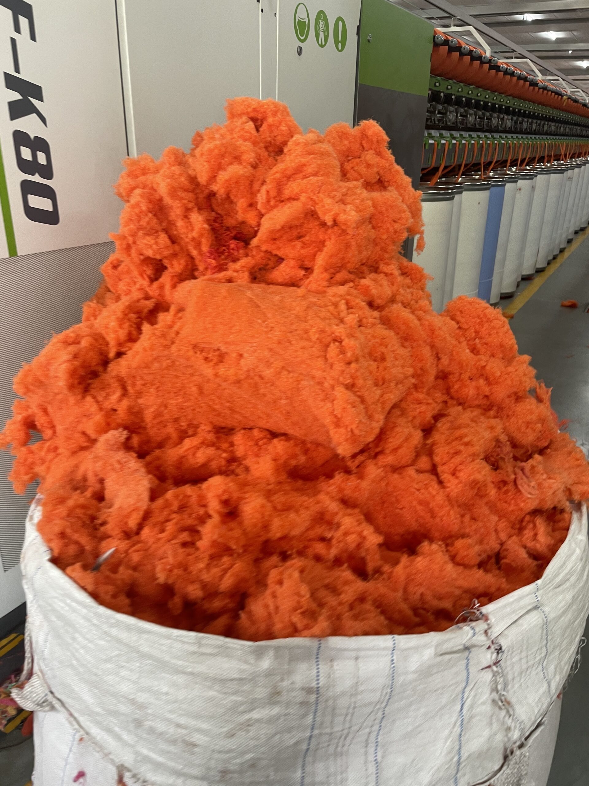 Orange pile of processed fibres in factory